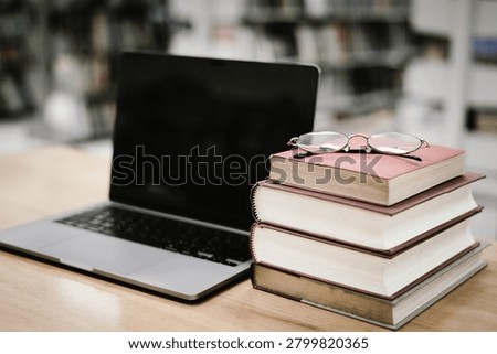 Laptop and Stack of Books in Library – Digital Education, Academic Research and Modern Learning Concept
