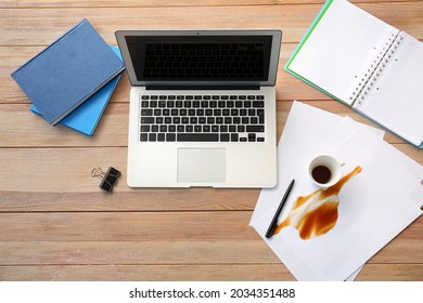 Laptop, Stationery And Spilled Coffee On Office Table