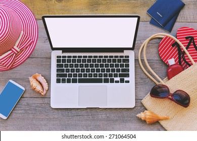 Laptop And Summer Vacation Items On Wooden Background. View From Above