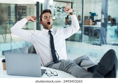 Laptop, tired or yawn and business man at desk in office with burnout or fatigue from workload. Computer, exhausted and stretching with sleepy employee in professional workplace for project deadline - Powered by Shutterstock