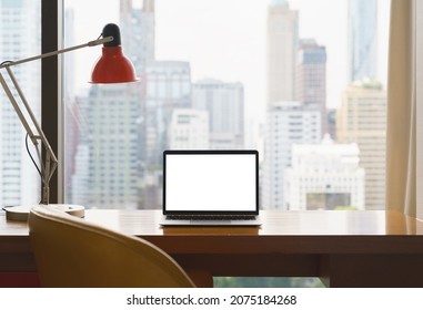 laptop white screen display on workspace see through city blur background