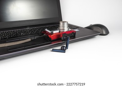 Laptop with wireless mouse, red digital camera, black wireless headphones and memory SD card - EDC everyday carry - empty space - white background - Powered by Shutterstock