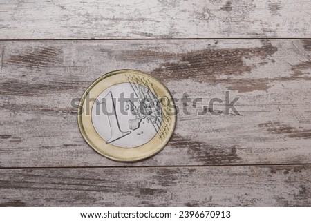 Large 1 euro coin on wooden background