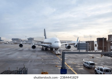 Large 4-engine passenger plane approaching jetway at London Heathrow airport 