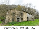 large abandoned and isolated semi-demolished stone house in the middle of the mountain. Cantabria, Spain.