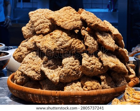 A large amount of fried crispy layers are piled up in the bamboo basket, and the golden crispy surface stands out, showing the details of the Guilin rice noodle ingredients stall.