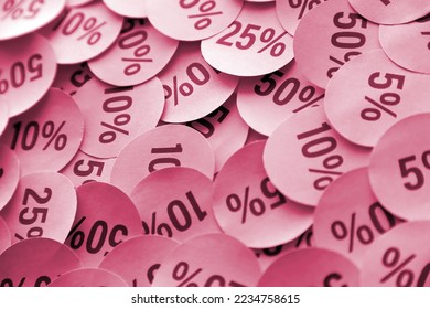Large amount of yellow stickers with percentage values for black friday or cyber monday sale. Abstract image of discount prices for any goods Image toned in Viva Magenta, color of the 2023 year