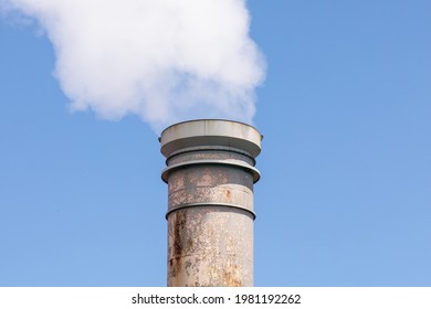 Large Amounts Of Steam Or Smoke Billowing From An Industrial Smoke Stack