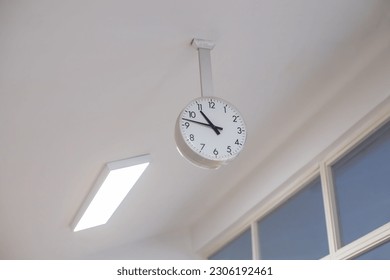 large analog clock hanging from ceiling