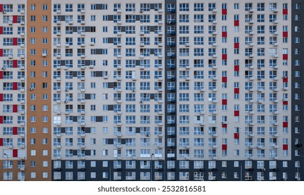 A large apartment building with many windows and a red and white trim. The building is empty and the windows are all open - Powered by Shutterstock