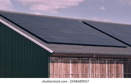 Large array of solar panels installed on a agracultural building roof promoting green energy transition in the Netherlands, a demonstration of sustainable energy solutions in everyday environments