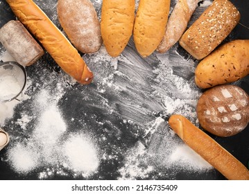 a large assortment of different breads laid out on a black background with flour, fresh hot pastries, wheat flour, bread production concept, place for text