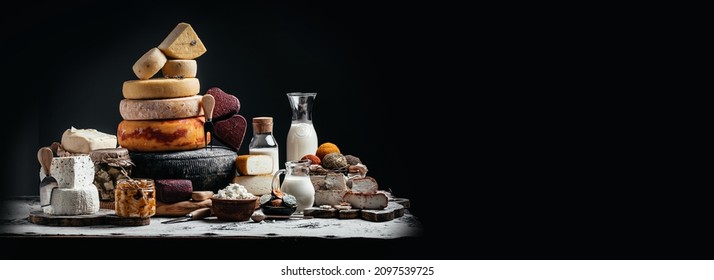 large assortment of international cheese Petit Basque, French cheese board of various types of soft and hard cheese. spanish manchego cheese on black background, Long banner format