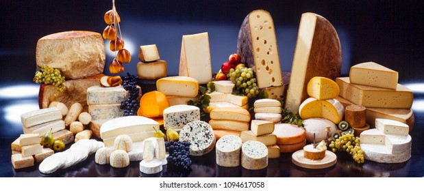 large assortment of international cheese specialities on black background - Shutterstock ID 1094617058
