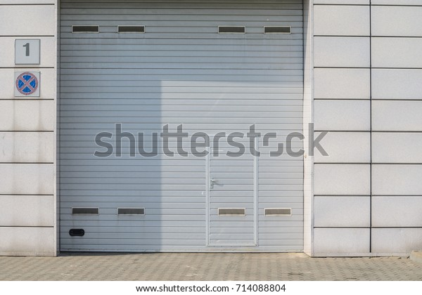 Large automatic up and over garage door\
with inclusion of smaller personal\
door.