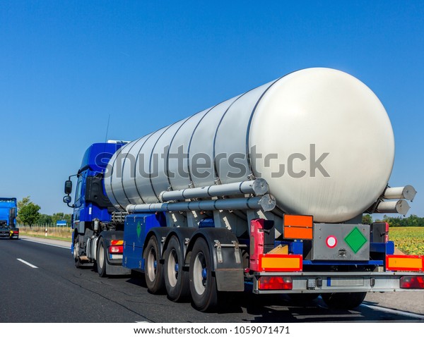 Large automotive fuel tanker truck driving\
on highway. Fuel\
transportation