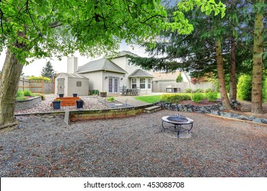 Large Backyard With Beautiful Landscape And Fire Pit. House Exterior.