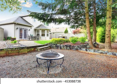 Large Backyard With Beautiful Landscape And Fire Pit. House Exterior.