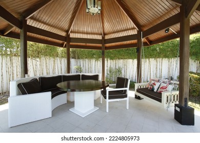 Large backyard gazebo with table and cushioned and hanging chairs
