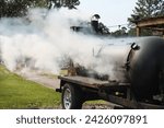 Large barbecue smoker grill at the park. Unleashing Flavors Amidst the Greens with a Hearty BBQ Session. A Smoky Affair with a Barbecue Grill. Slow cooking.