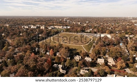 A large bare hill surrounded by large houses
