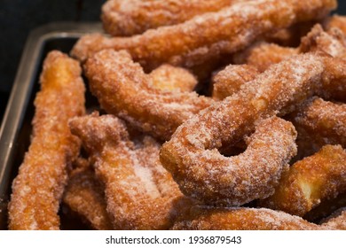 Large Batch Of Homemade Golden Soft And Crispy Churros With Cinnamon Sugar In A Tray, Closeup, Landscape Format