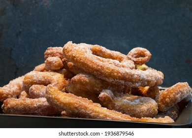 Large Batch Of Homemade Golden Soft And Crispy Churros With Cinnamon Sugar In A Tray, Closeup, Landscape Format