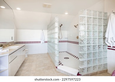 large bathroom primary washroom dated decor wine colored bath tub glass block shower long countertop and mirrors