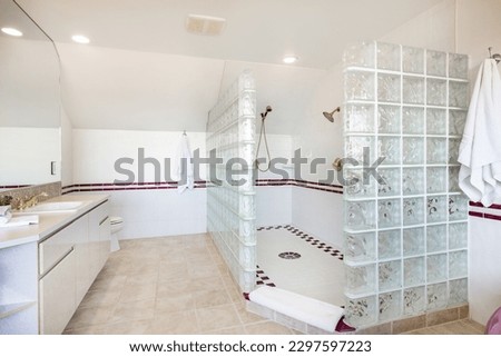 large bathroom primary washroom dated decor wine colored bath tub glass block shower long countertop and mirrors