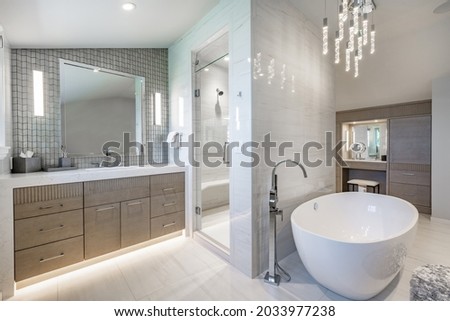 large bathroom with white fixtures tiles oval bathtub and glass walls