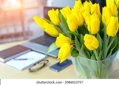 Large Beautiful Bouquet Of Yellow Tulips On A Desk In The Office. Congratulations On The Holiday Or Birthday. Flowers As A Gift.