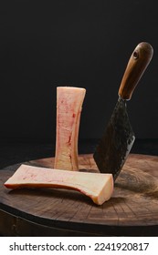 Large beef bone marrow chopped with cleaver on half on wooden stump
