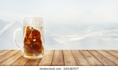 Large Beer Mug With Light Cold Beer Standing On Wooden Table Over Snow-capped Mountains Background. Holidays, Vacation, Drinks, Taste, Ad And Oktoberfest Concept. Design For Wallpaper