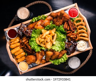 Large beer plate, large set of beer snacks. assorted snacks deep-fried beer. Food for a holiday for a large company. hot meat snacks for beer served on wooden dish board top view, flat lay