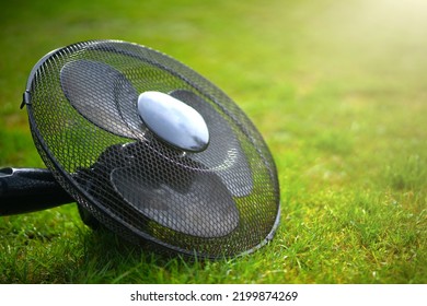 A Large Black Fan On A Green Background. Cooling Fan Blades. Cool The Air With A Fan.