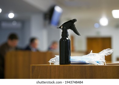 A Large Black Spray Bottle With Disinfectant Liquid And Protective Medical Masks Lie On A Table In A Conference Room During A Business Meeting, A Meeting Of Officials Or Negotiations. Close-up