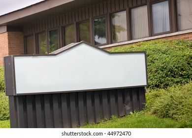 A Large Blank Sign In Front Of A Small Office Building.