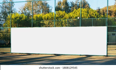 Large Blank White Poster With Mockup Space Hanging On Metal Fence Of Play Ground Outside