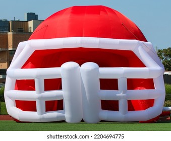 A Large Blow Up Red And White Football Hemet Used As A Tunnel For A High School Football Team To Enter The Field