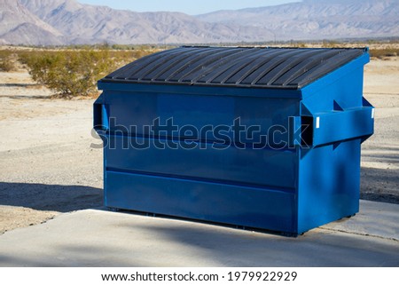 A large blue commercial dumpster for trash or recycling. 
