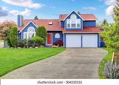 Large Blue House With White Trim, And Well Kept Lawn, Along With Two Garage Spaces.