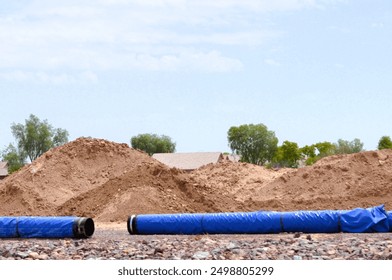 large blue plastic utility pipes waiting installation at construction site