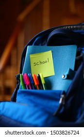 Large blue school backpack with multi-colored pens and notebook