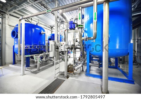 Large blue tanks in a industrial city water treatment boiler room. Wide angle perspective. Special equipment, technology, drinking water supply, chemical modifications, environmental conservation