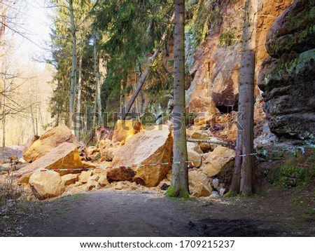 Large boulder stones block the forest road. Zone of natural disasters during rain. Large masses of rocks slip along slope of hill, destroy forest way