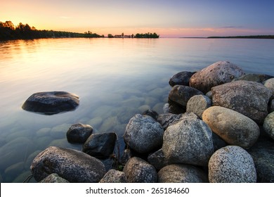 Large boulders on lake shore at sunset. Minnesota, USA
