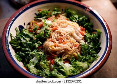 A Large Bowl Of Asian Noodles And Fresh Salad.