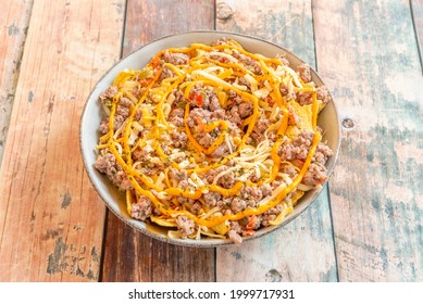 Large Bowl Of Corn Nachos With Lots Of Stewed Minced Meat, Cheddar Cheese In Sauce, Shredded Cheese And Dried Oregano