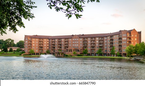 Large Brick Apartment Building In Front Of A Lake At A Retirement Community