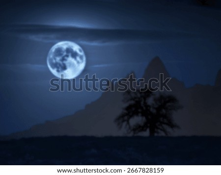 A large, bright full moon illuminates a dark landscape featuring silhouetted mountains and a solitary tree in the foreground. The scene evokes a sense of serenity and mystery.